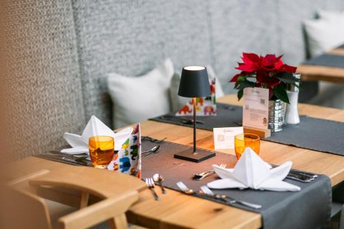 a table with two glasses and a lamp on it at Familienresort Buchau in Maurach