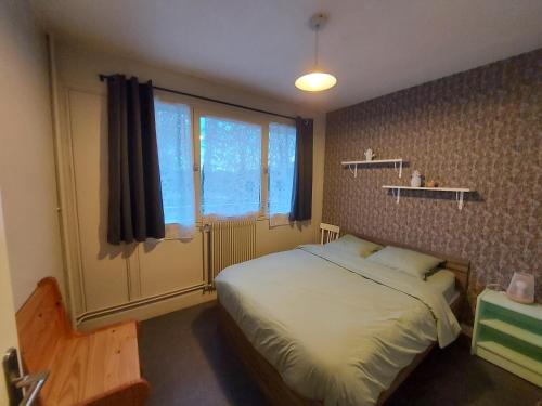 um quarto com uma cama e uma grande janela em Appartement Rennes stade em Rennes