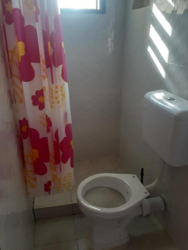 een badkamer met een toilet en een douchegordijn bij Ngala Blessed Apartment in Malindi
