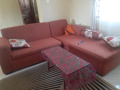 een woonkamer met een rode bank en een tafel bij Ngala Blessed Apartment in Malindi