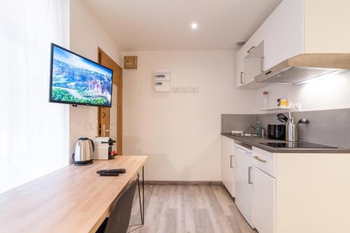 eine Küche mit einer Theke und einem TV an der Wand in der Unterkunft Lille Grand-place : Functional and quiet studio ! in Lille