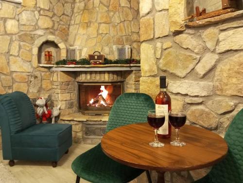 a table with two glasses of wine and a fireplace at Anneta s StudioBear s Path in Sklíthron