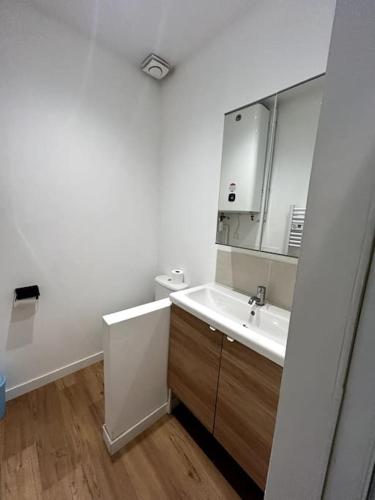 a white bathroom with a sink and a mirror at "Le N1" Beaucaire centre-ville in Beaucaire