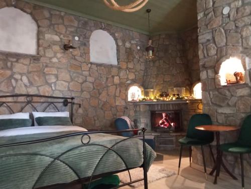 a bedroom with a stone wall with a bed and a fireplace at Anneta s StudioBear s Path in Sklíthron