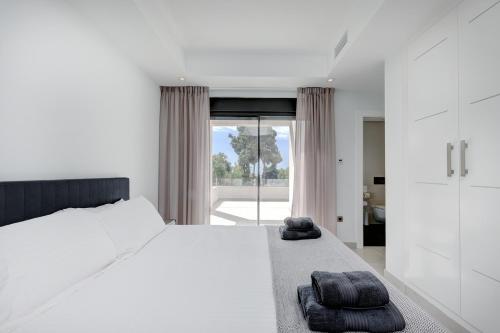 ミハス・コスタにあるVilla Casa Cazorla, Mijas Costaのベッドルーム1室(白いベッド1台、タオル2枚付)