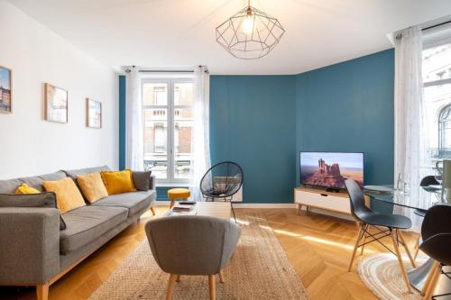 uma sala de estar com um sofá e uma parede azul em Vieux Lille - center apartment! em Lille