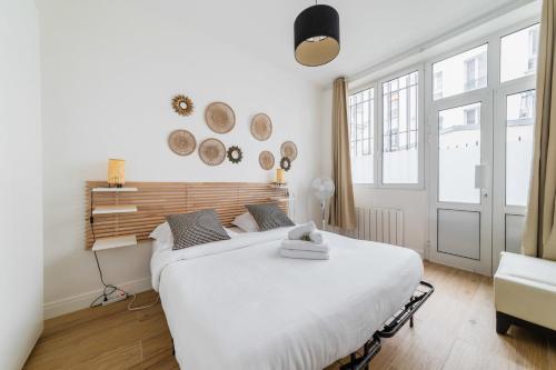 a white bedroom with two beds and a window at Appartement cosy refait a neuf - Paris 19 - 4P in Paris