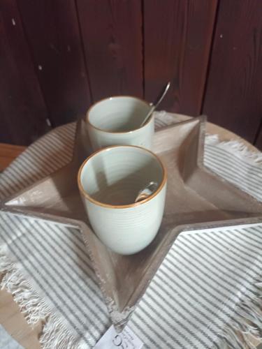 two bowls are sitting on a plate on a table at Chalet des secrets in Lyaud