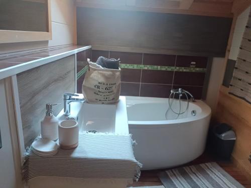 a bathroom with a tub and a sink and a bath tub at Chalet des secrets in Lyaud