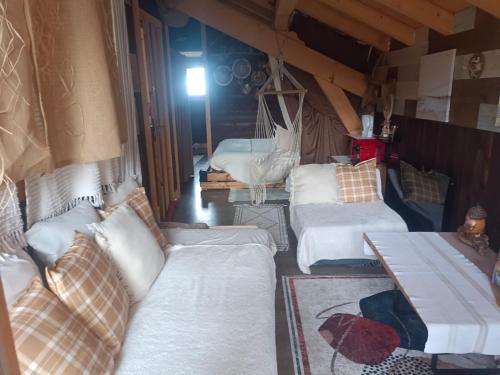 a room with three beds and a couch and a table at Chalet des secrets in Lyaud