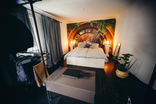 um quarto com uma cama e um quadro na parede em NEW人 Dachterrasse PRIME/TV 人 4min zum Bhf em Kornwestheim