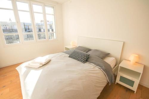 1 dormitorio con 1 cama blanca grande y 2 almohadas en Lille République-Nice and bright flat with Balcony, en Lille