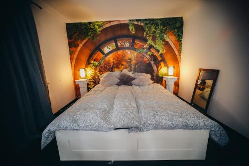 a bedroom with a large bed with a painting on the wall at NEW人 Dachterrasse PRIME/TV 人 4min zum Bhf in Kornwestheim