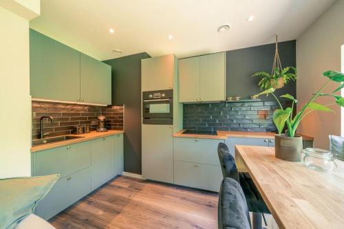eine Küche mit blauen Schränken und einem Holztisch in der Unterkunft Salty Vibes in Middelkerke
