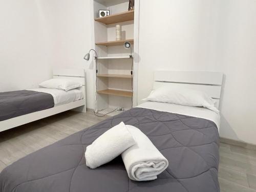 1 dormitorio con 2 camas y toallas en la cama en Paloma center town apartment en Bellagio