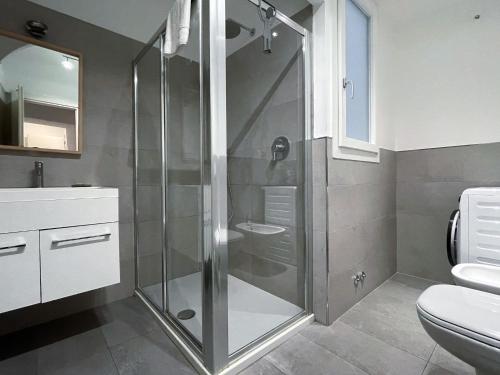 y baño con ducha, aseo y lavamanos. en Paloma center town apartment en Bellagio