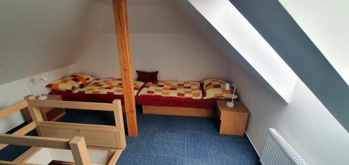 a small room with a bed and a ladder at Apartmány Semily in Semily