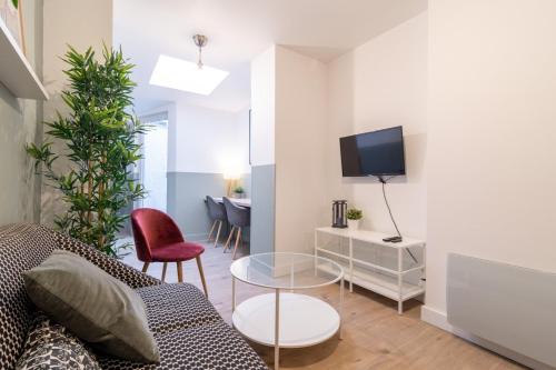 uma sala de estar com um sofá e uma televisão em Lille Centre: 2bed 2bath apartment! em Lille