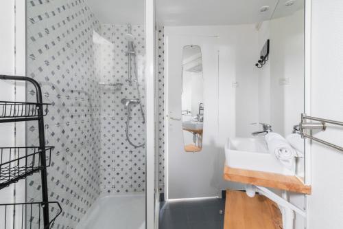 une salle de bain blanche avec une douche et un lavabo dans l'établissement Agréable studio cœur de paris - Paris 6 - 2P - FLAT-GUEST, à Paris