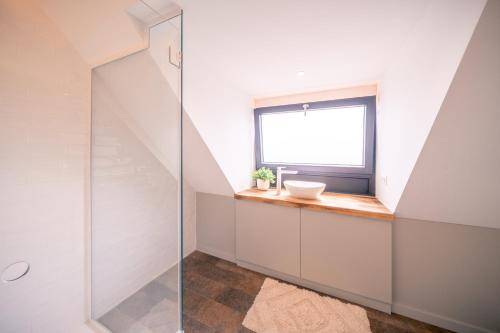 a bathroom with a sink and a window at Salty Vibes in Middelkerke