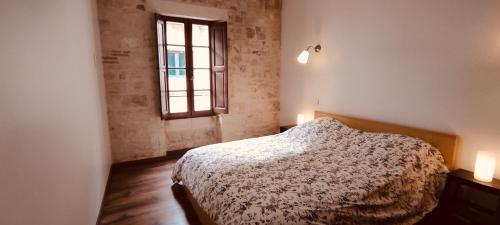 une chambre avec un lit et une fenêtre dans l'établissement LOUSTERAPH, à Saint-Rémy-de-Provence