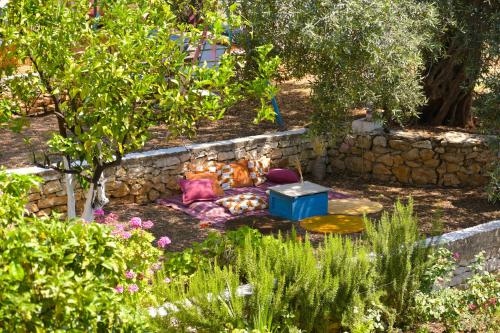 um jardim com um sofá no chão ao lado de uma parede de pedra em Vila Toskaj em Vlorë