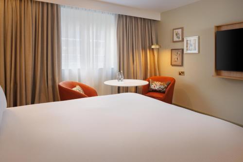 a hotel room with a bed and a table and chairs at DoubleTree by Hilton Bristol North in Bristol