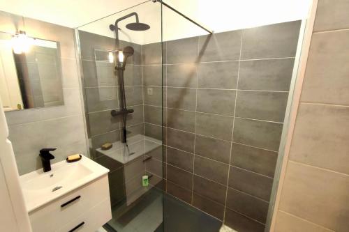 ein Bad mit einer Dusche, einem Waschbecken und einem Spiegel in der Unterkunft Superbe 3 pièces sur la baie de Théoule in Théoule-sur-Mer