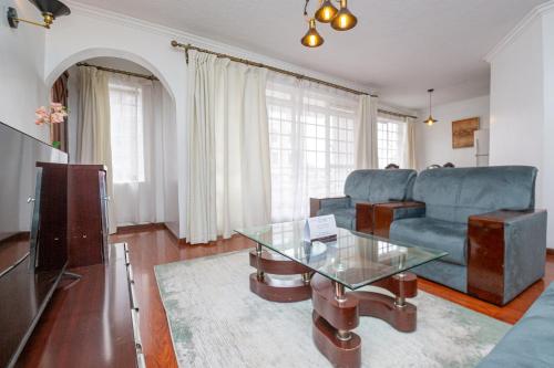 sala de estar con sofá y mesa de cristal en Eldon Apartments & Suites, en Nairobi