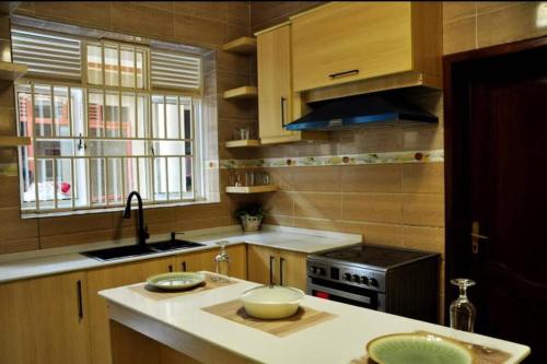 a kitchen with wooden cabinets and a counter top at VILLA MODERNE CHEZ YVONNE in Kigali