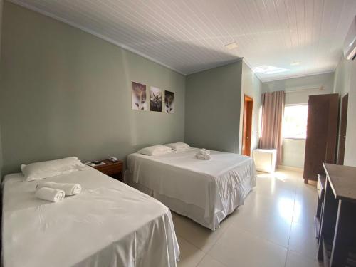 Zimmer mit 2 Betten und weißer Bettwäsche in der Unterkunft Pousada Mirante da Lua in Alto Paraíso de Goiás