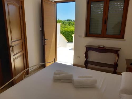 una camera da letto con un letto e due asciugamani di Agriturismo Terra dei Profumi a Otranto