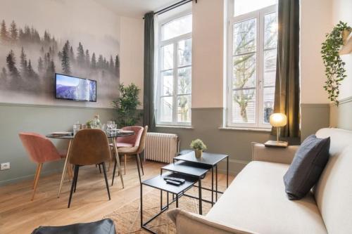 un salon avec une table et un canapé dans l'établissement Lille Hypercentre - bright apartment!, à Lille