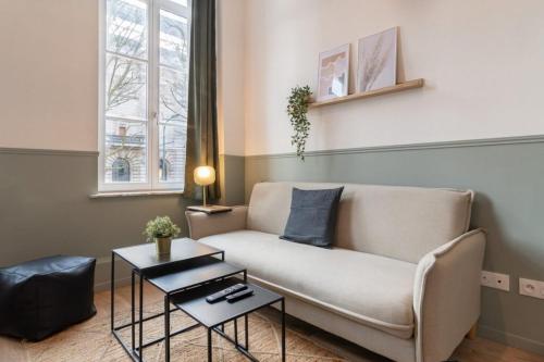 un salon avec un canapé et une table dans l'établissement Lille Hypercentre - bright apartment!, à Lille