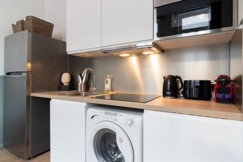 une cuisine avec une machine à laver sous un comptoir dans l'établissement Lille Hypercentre - bright apartment!, à Lille