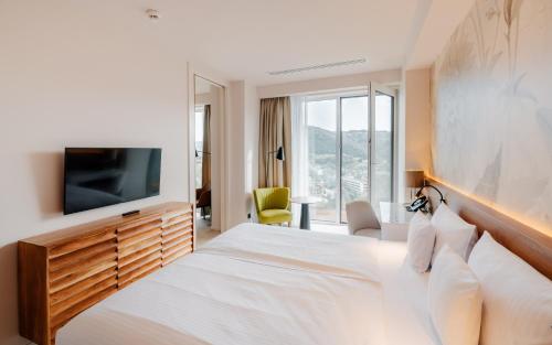 a hotel room with a bed and a tv at Hotel Pieniny Grand Wellness & SPA - Destigo Hotels in Szczawnica