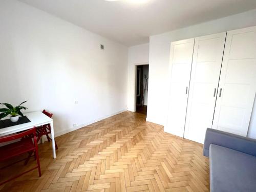 an empty room with a piano and a wooden floor at Ładne mieszkanie Świętojerska in Warsaw