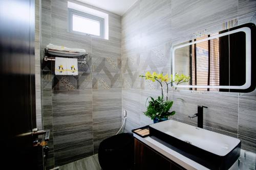 uma casa de banho com um lavatório e um espelho em My's Flower Villa em Hoi An