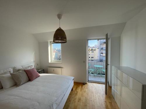 1 Schlafzimmer mit einem weißen Bett und einem Balkon in der Unterkunft Traumwohnung mit Balkon im 17 Bezirk in Wien