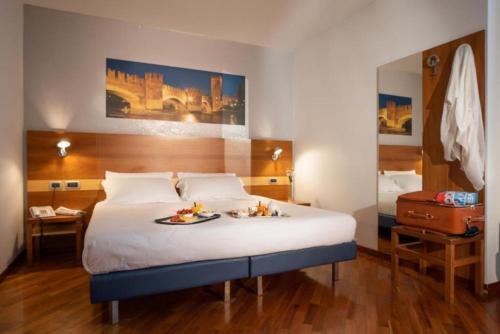 a hotel room with a bed with a tray of food on it at Best Western Hotel Fiera Verona in Verona