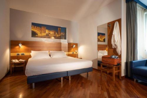 a hotel room with a bed and a blue chair at Best Western Hotel Fiera Verona in Verona