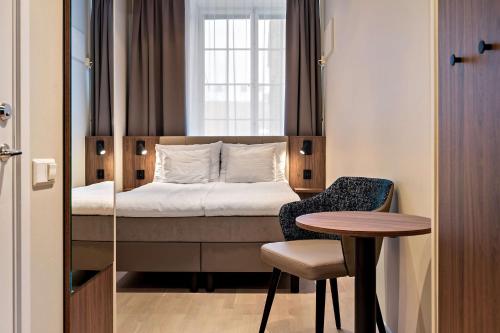 a bedroom with a bed and a table and a chair at Best Western Hotel Karlaplan in Stockholm