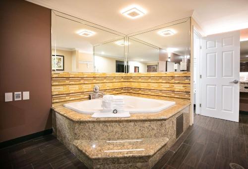 a bathroom with a sink and a large mirror at Rodeway Inn & Suites in Bellflower