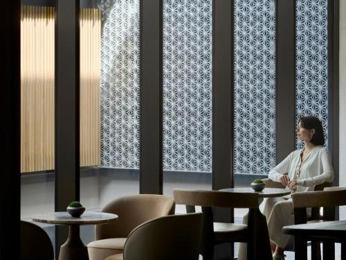 a woman sitting at a table in a restaurant at Dusit Thani Kyoto in Kyoto