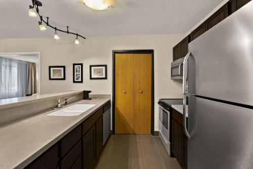 a kitchen with a refrigerator and a sink at Comfort Inn Ludington near US-10 in Ludington