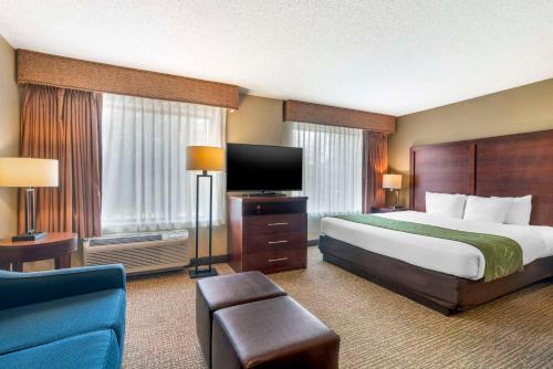 a hotel room with a bed and a flat screen tv at Comfort Suites Wilmington near Downtown in Wilmington
