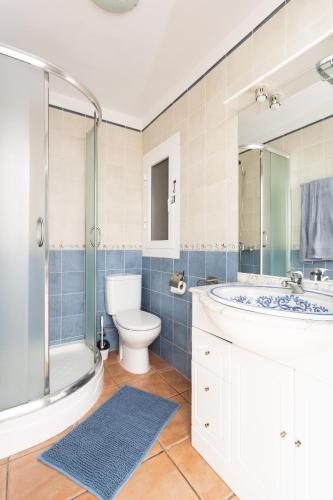 a bathroom with a toilet and a sink and a shower at Frontline Duplex Las Arenitas with pool in Candelaria