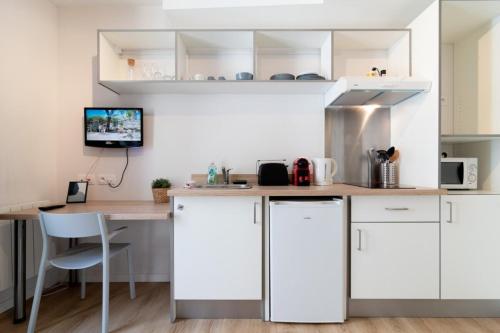 une cuisine avec des armoires blanches et un comptoir en bois dans l'établissement Lille Hypercentre - Nice equipped studio, à Lille