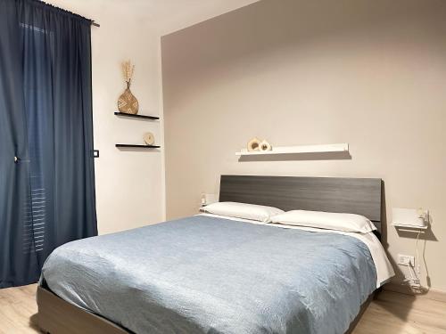 um quarto com uma cama grande e um cobertor azul em Casa Bolina - Mini appartamento em Taranto