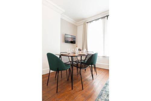 a dining room with a table and green chairs at Lille Centre - 2BR in the heart of Lille! in Lille